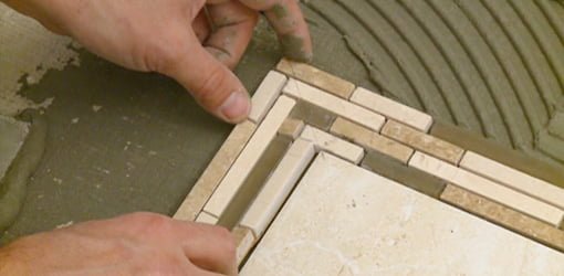 Laying mosaic tile border.