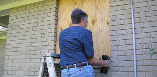 Using a cordless drill to attach plywood to a window