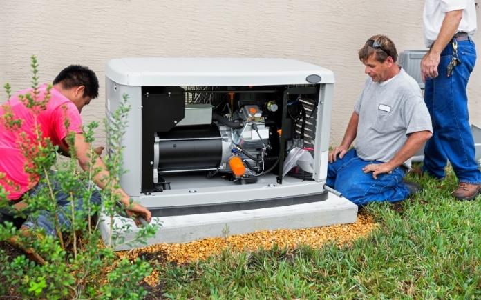Workers service an automatic standby generator