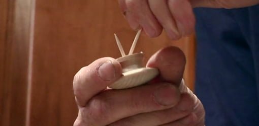 Repairing wooden cabinet knob with toothpicks.