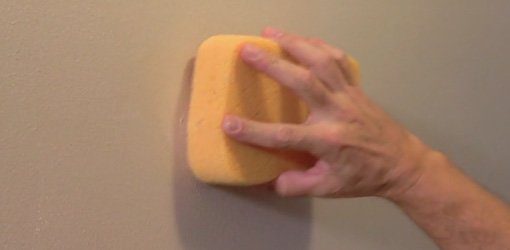 Using sponge to bend drywall hole repair.