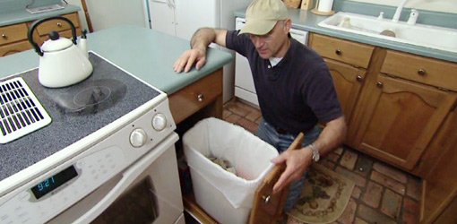 Joe Truini with homemade pullout kitchen trash can.