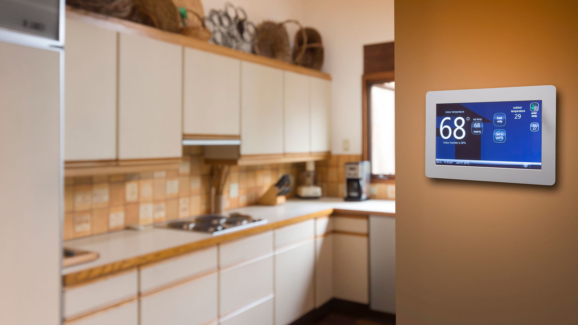 This smart thermostat installed on a wall in the kitchen works with a geothermal heat pump to provide warmth