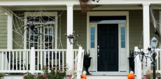 Home's entry decorated for Halloween with fake spiders and jack-o-lanterns