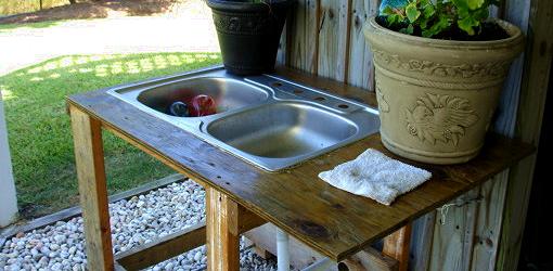 Outdoor utility sink made from old kitchen sink, plywood top, and wood base