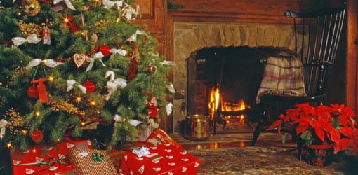 Christmas tree with gifts next to fireplace