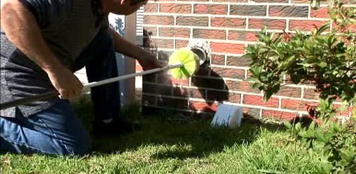 Man cleaning dryer vent