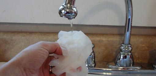 Wetting paper towel under sink faucet