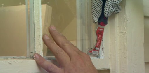 Pressing glazier’s points into the window sash to hold the glass pane in place.