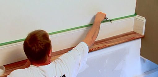 Using putty knife to press down painter's tape