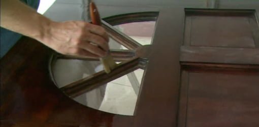 Applying clear finish to an entry door.