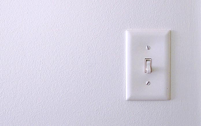 Single-pole light switch on a white wall