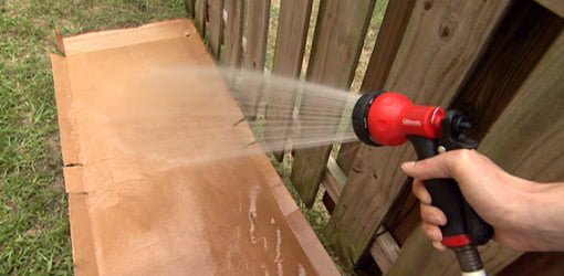 Spraying cardboard with hose