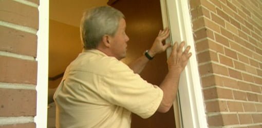 Danny Lipford replacing weather stripping on door.