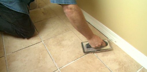 Putting grout on a tile floor.