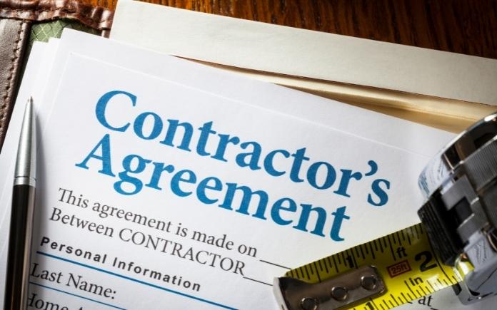 Contractor's agreement with pen and tape measure on desk