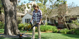 Woman using the Worx GT cordless string trimmer and edger