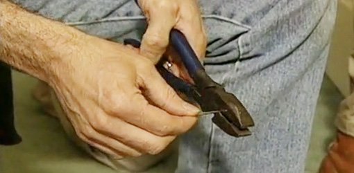 Cutting point off nail with lineman's pliers to make drill bit.