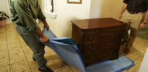 Using a moving pad or blanket to slide heavy furniture across the floor.