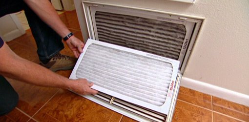 Changing the air filter on the return of a home HVAC system.