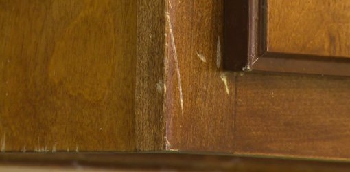 Unsightly scratches on stained wood cabinets before repair.