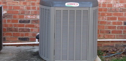 Lennox HVAC unit outside in front of brick wall.