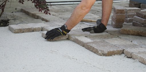 Laying pavers on a base of crushed limestone topped with sand.