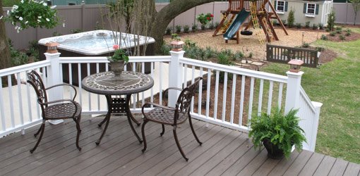 Completed backyard makeover with composite deck, hot tub, and playset.