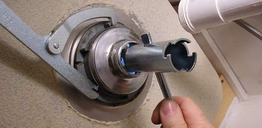 Using special locknut and basket wrenches to remove a sink strainer.