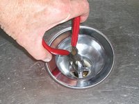 Utilizar unos alicates de punta fina para evitar que el colador del fregadero gire.