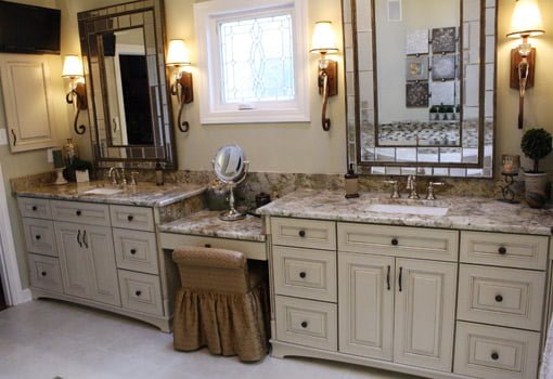 His and hers vanity with granite countertops and stained glass window.