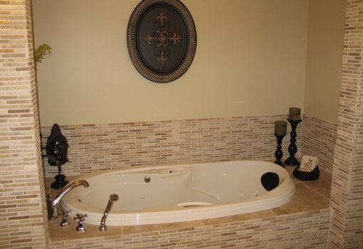 Updated bathtub with small tile surround.