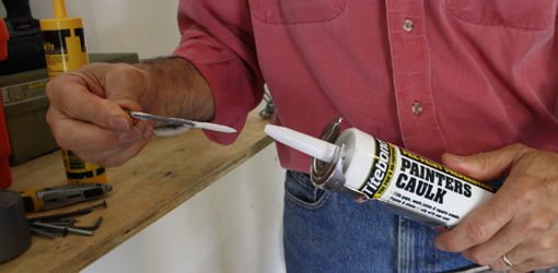 Using a nail to seal up the nozzle on a tube of caulking.
