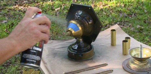 Spray painting an outdoor brass light fixture.