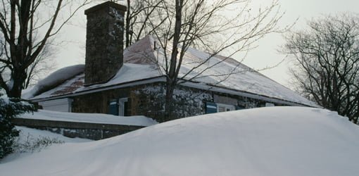 House covered in snow from winter storm.