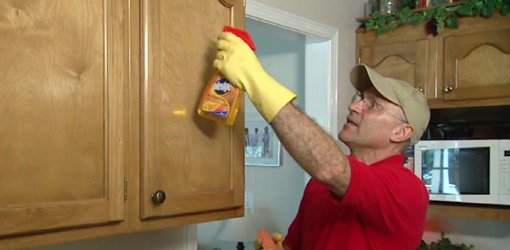Using citrus cleaner to clean kitchen cabinets.
