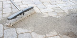 Sweeping sand over patio pavers