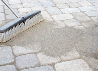 Sweeping sand over patio pavers