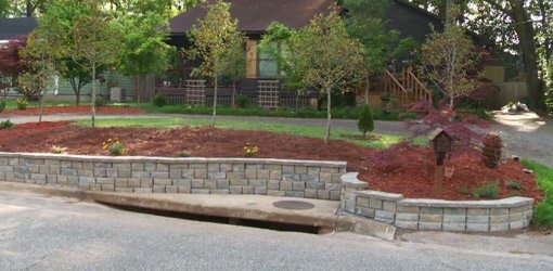 Completed stackable block retaining wall in front of house.