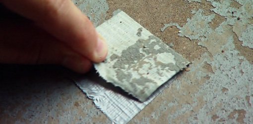 Pulling duct tape off a concrete surface.