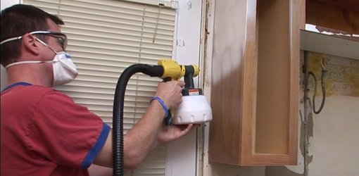 Using an airless sprayer to paint kitchen cabinets.