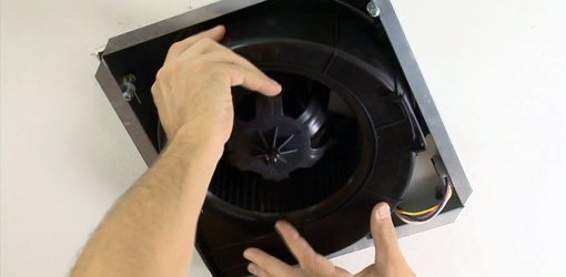 Installing a bathroom vent fan motor in housing.