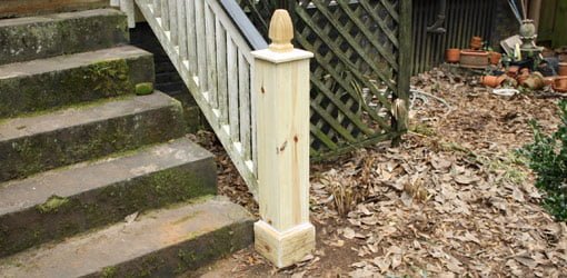 Newel post on porch with newly replaced facing boards, cap, and finial.