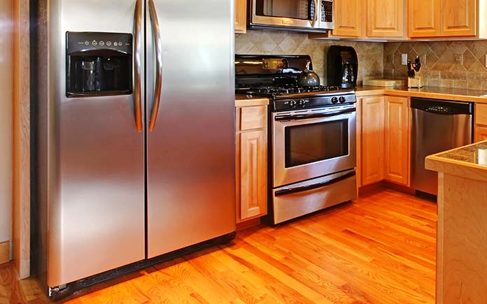 Kitchen with wood floor and a focus on the refrigerator coils