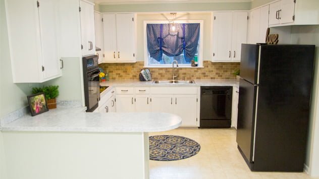 The Rhoads' updated kitchen features white shaker-style cabinets and faux granite countertops. 