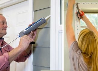 Danny Lipford caulks around a home's windows while Chelsea Lipford Wolf applies window insulation.