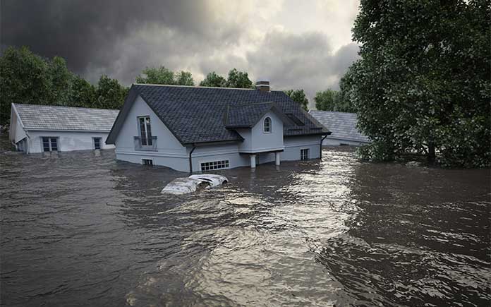 Oversvømmet hus, sett fra gaten, med vann opp til toppen av vinduer og dører
