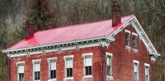 Red metal roof on brick home, as seen on an overcast day