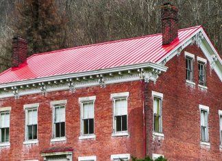 Red metal roof on brick home, as seen on an overcast day