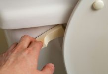 Closeup of a man flushing a toilet after using the bathroom